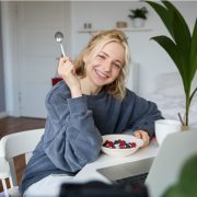 Жена закусва кисело мляко с плодове и пчелен прашец за отслабване.