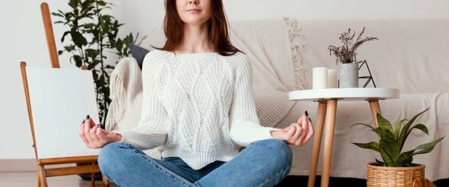 Жена медитира вкъщи за справяне с преумората.
