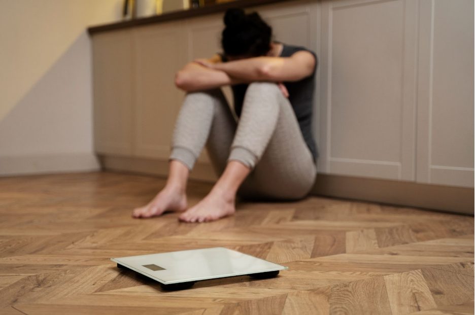 Жена на пода с кантар до нея