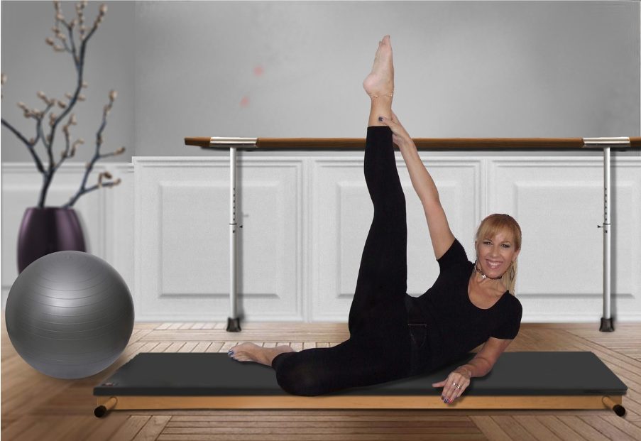 Усмихната жена прави упражнение с вдигнат крак върху постелка на пода.