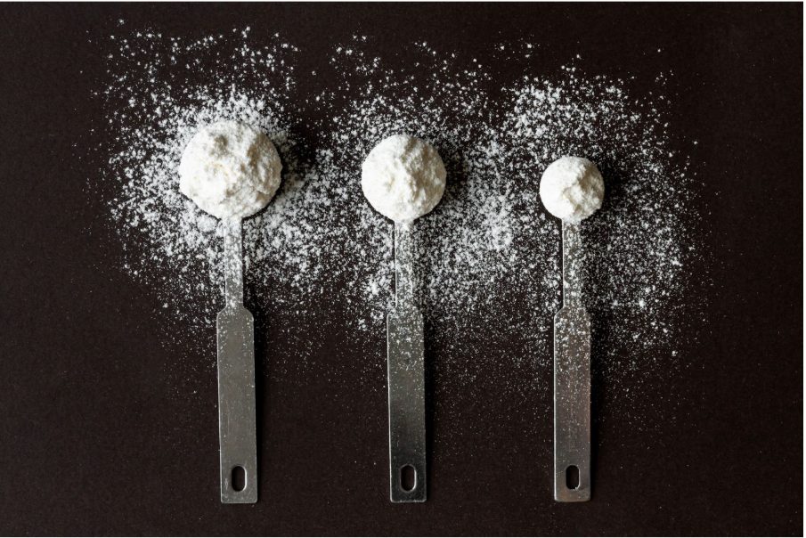 Три лъжици с различен размер, съдържащи прахообразно вещество.