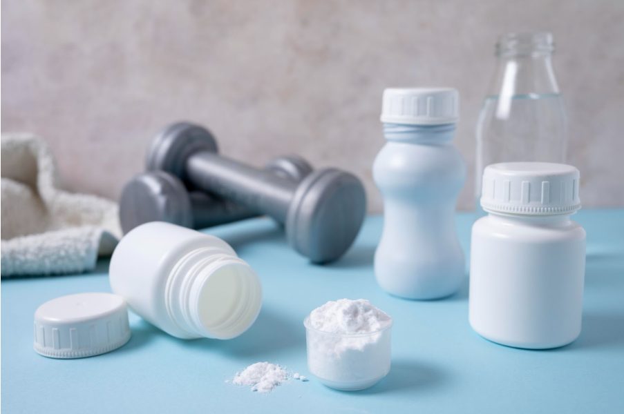 Дъмбели за тренировка и малки контейнери с Л-карнитин.