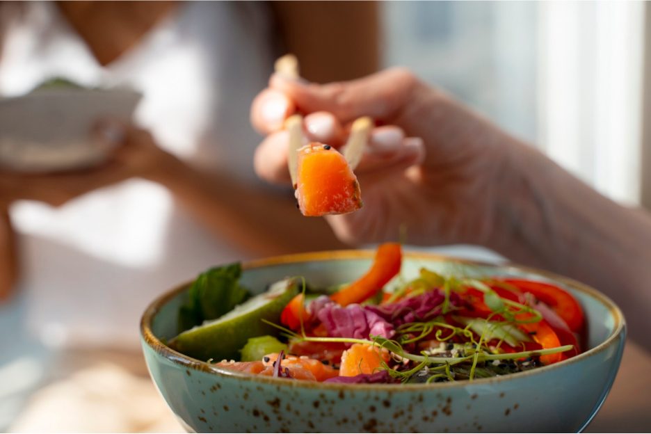 Жена похапва богата на зеленчуци салата